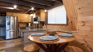 Een moderne keuken met houten kastjes, roestvrijstalen apparatuur en een centraal kookeiland met zitplaatsen.