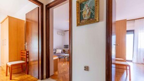 Une pièce avec un plancher en bois, une chaise en bois, un lit, un bureau et un tableau accroché au mur.