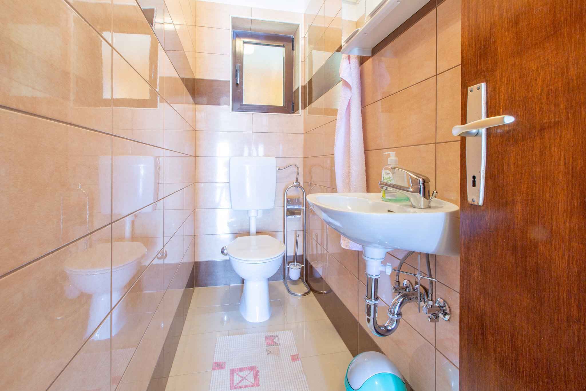 A modern bathroom with a toilet, sink, and shower.