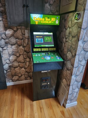A 3D golf arcade machine with a screen displaying the game 'Golden Tee 3D Golf.' - Private waterfront retreat in the Pocono mountains. Hot tub, Fire pit, Dogs ok (Cresco)