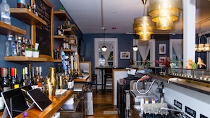 A bar area with wooden shelves, a chalkboard menu, and various bottles. - The Colonial Inn, an Ascend Collection Hotel (Hillsborough)