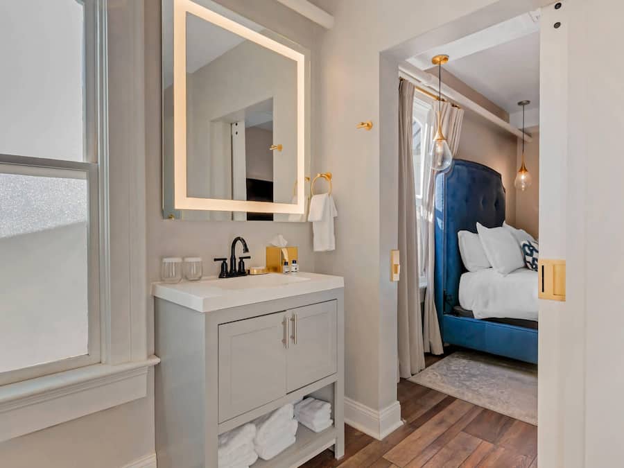 Une salle de bain avec un miroir, un lavabo et un porte-serviettes.