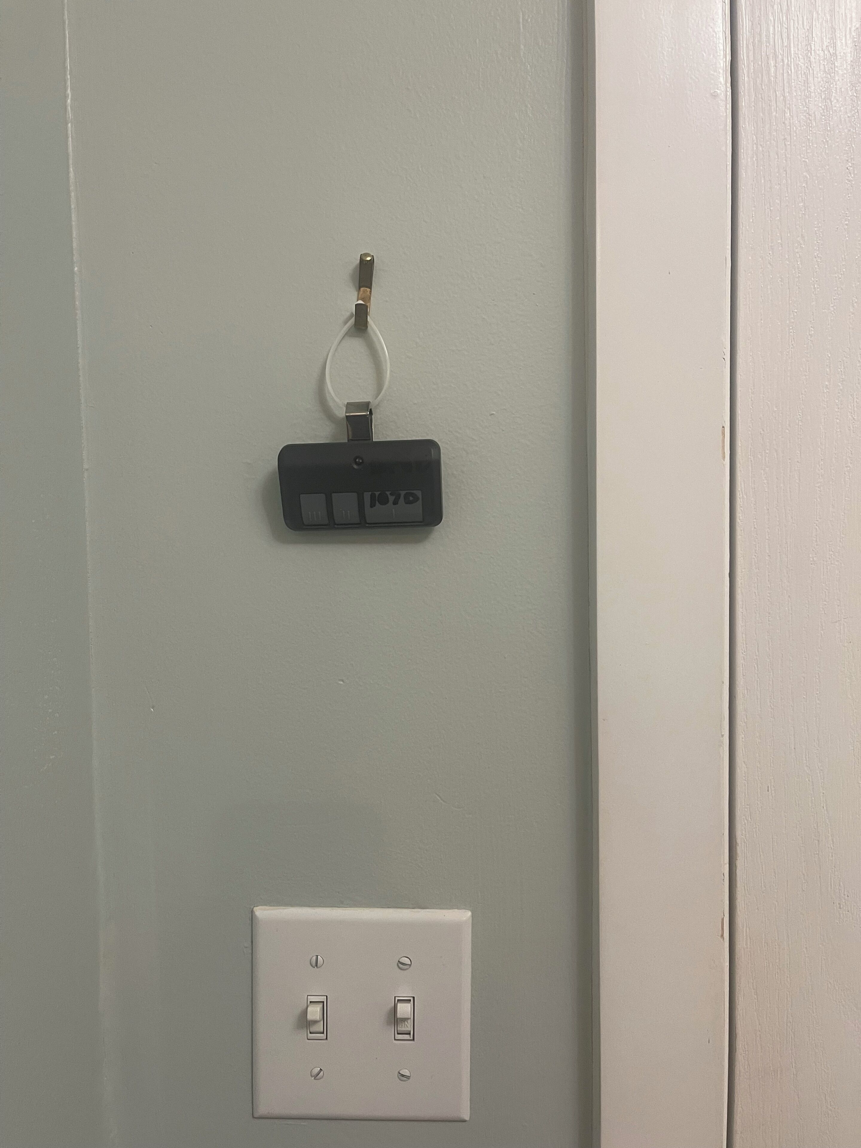 A wall with a power outlet and a keychain.