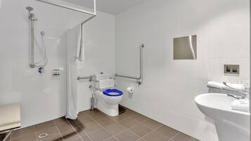 Un baño moderno con ducha, inodoro y lavamanos.