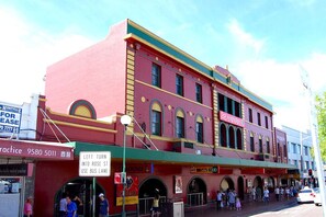 A red building with multiple storefronts, including a medical practice and a restaurant. - Meridian Hotel (Hurstville)