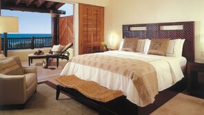 Relax in this serene bedroom with a large bed, chaise lounge, and scenic views.