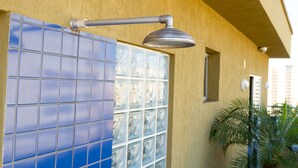 A building exterior with a tiled wall, a metal pipe, and a small window. - Plaza Inn San Conrado (Goiânia)