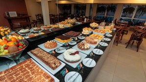 A buffet with various desserts and fruits. - Evora Hotel (Florianópolis)