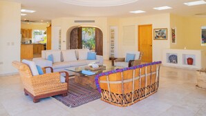 A spacious living area with a sofa, armchairs, and a coffee table.