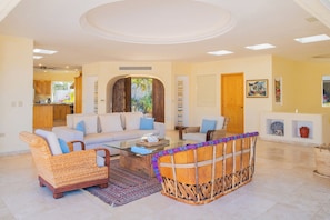 A spacious living area with a sofa, armchairs, and a coffee table.