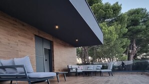 An outdoor seating area with modern lounge chairs and a wooden deck. - LuxuriousVilla , sauna, sea view, 200 m from the beach (Fažana)