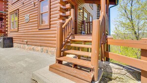A wooden log cabin with a wooden staircase leading to a porch. - 'Mountain Dreams' Cabin: Hot Tub, Sauna & Views! (Sevierville)