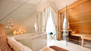 A modern bathroom with a glass-enclosed shower, a bathtub, and a wooden sauna area.