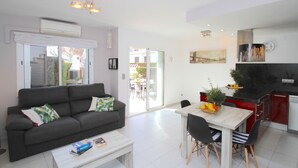 A modern living room with a sofa, coffee table, and dining area with chairs and a table. - CALETA townhouse 1st line to the sea, communal swimming pool (Miami Playa)