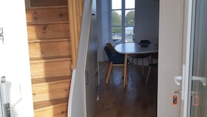 A staircase with wooden steps leading to a dining area with a table and chairs.