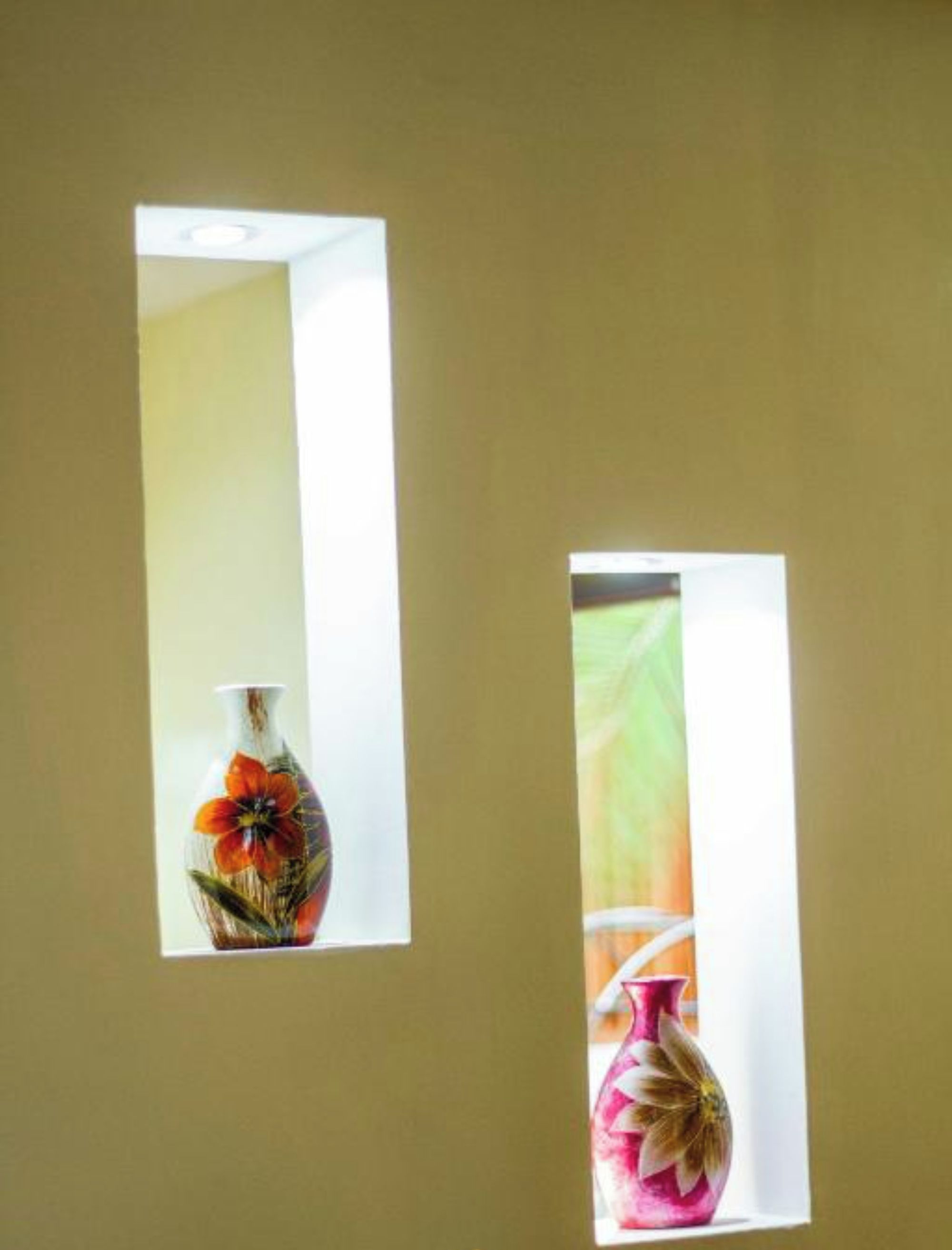 Two vases through windows on a wall.