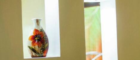 Two vases through windows on a wall.