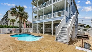A two-story building with a pool, a staircase, and a balcony. - Gorgeous Oceanfront Beach House, Outdoor Pool | Blue Heaven (North Myrtle Beach)