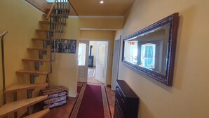 A staircase with wooden steps and metal railings, a red carpet, and a mirror on the wall. - Holiday house Fichtenwalde, 160m², 2.5 BZ, 3SZ, WZ, dining room, kitchen, garden, VDSL (Beelitz)