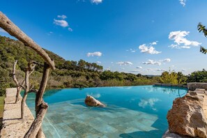 A clear blue pool with natural rock formations and trees in the background. - Stone villa in a natural environment with 3 bedrooms, 2 bathrooms, barbecue, wifi and pool (Inca)