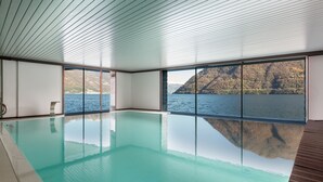 A large indoor swimming pool with a view of a lake and mountains. - Marvelous Lake Destination eco-friendly villa (Brienno)
