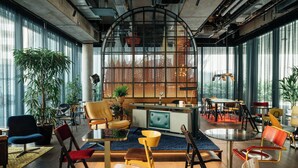 A modern interior with a central seating area, large windows, and a variety of chairs and tables. - Ruby Ella Hotel Cologne by IHG (Cologne)