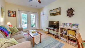 A living room with a sofa, coffee table, bookshelf, and a television.