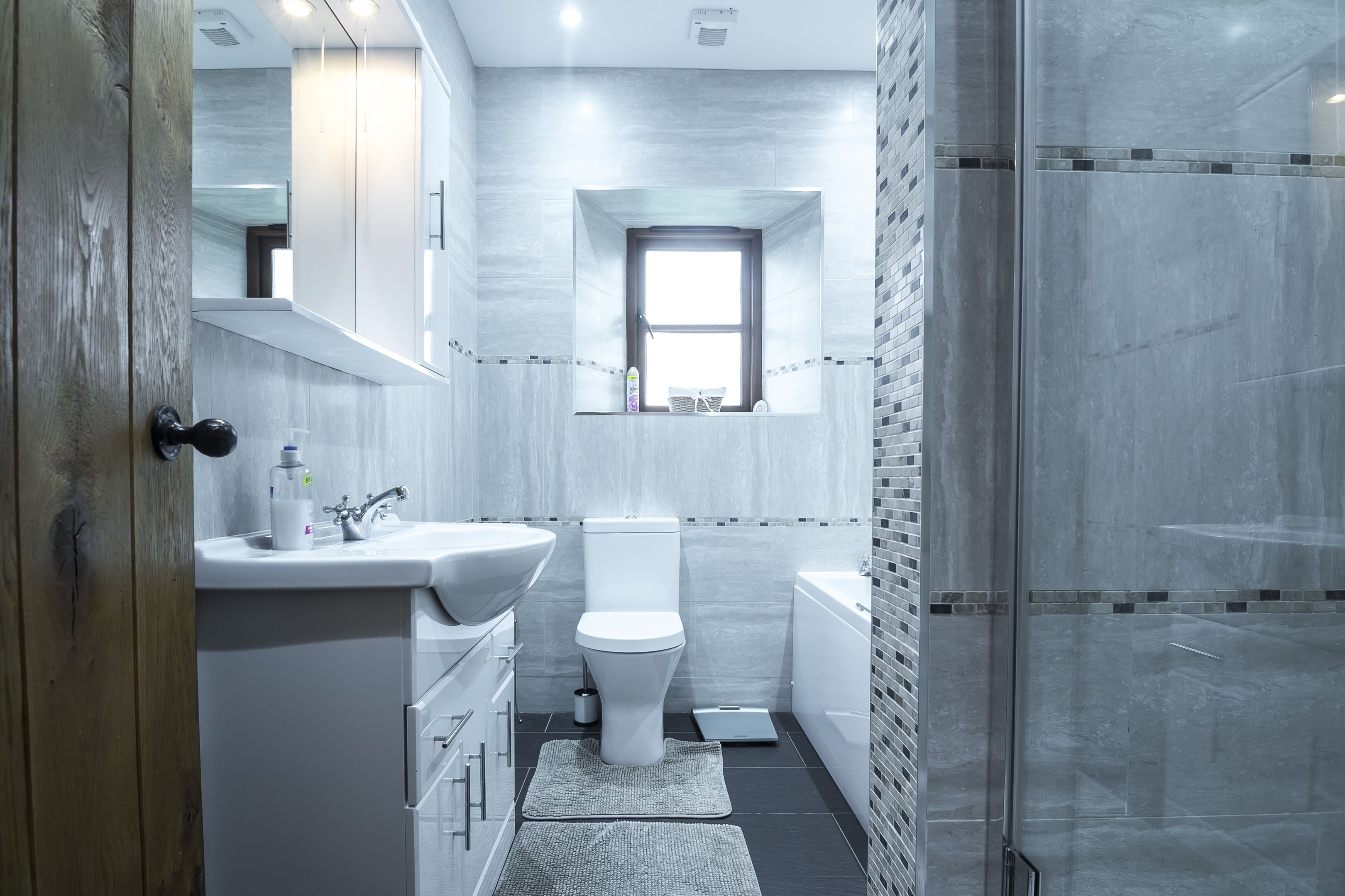 A modern bathroom with a sink, toilet, and shower.