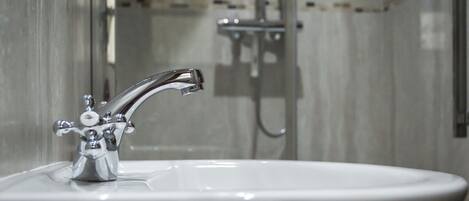 Un baño con un lavamanos moderno y ducha.