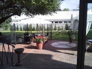 An outdoor patio area with a gazebo, seating, and potted plants. - Hotel Bertramshof (Wismar)