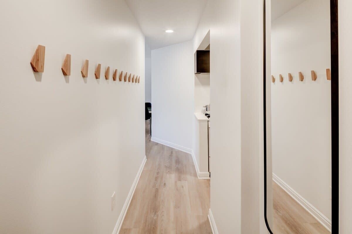 Un couloir orné de décorations murales en bois, un coin cuisine et un plancher en bois.