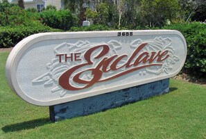 A sign with the text "THE ECLAVE" and the number "3655" on a blue base. - 🦩Book Me Baby! Endless Summer at The Enclave 204B~Heart of Destin Location🦩 (Destin)