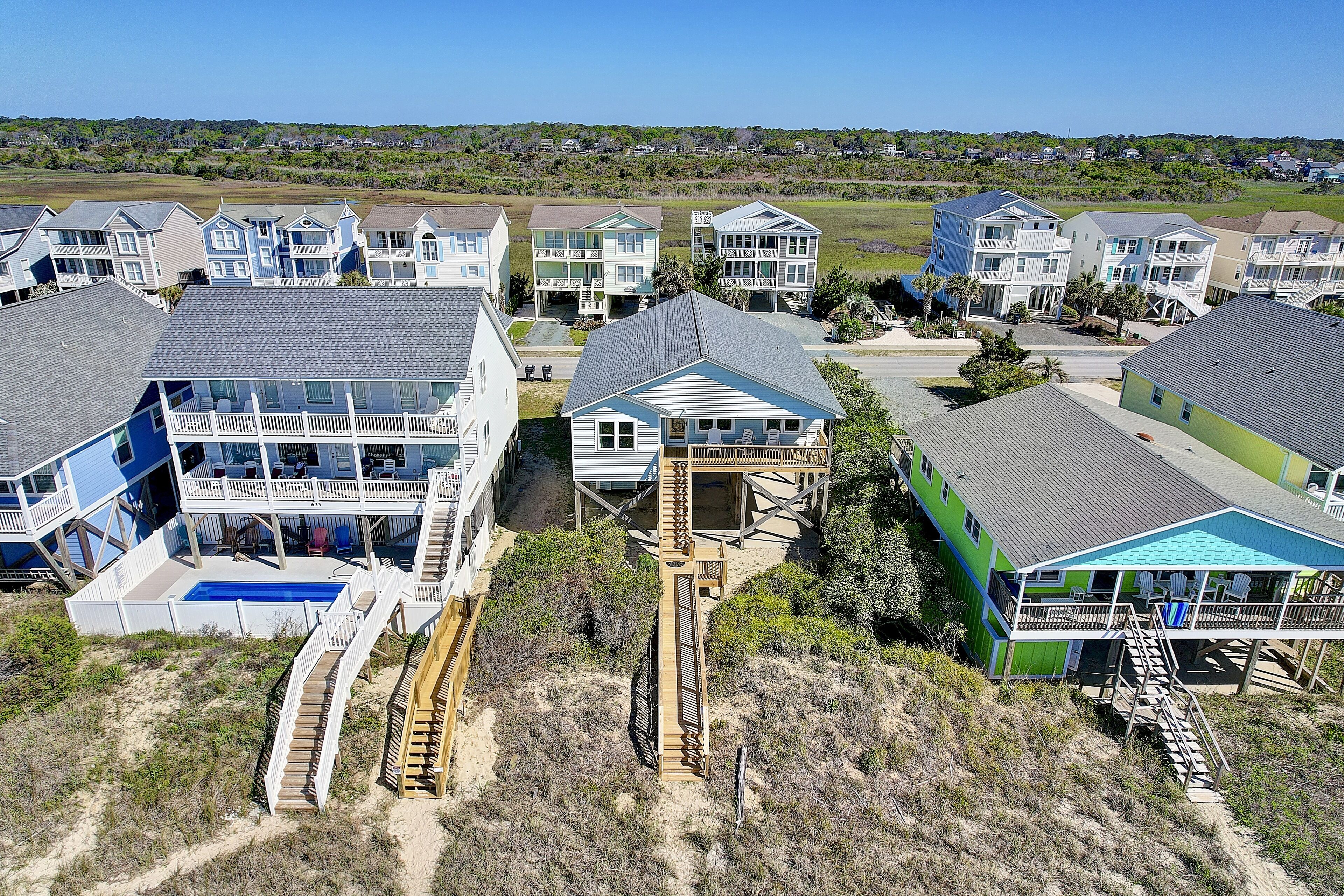 A coastal residential area with houses featuring balconies and a swimming pool.