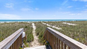 A wooden boardwalk leading to a beach with a clear view of the ocean and sandy dunes. - "Close Call" - Oceanfront Home, 4 Bedrooms / 3 Bathrooms (Holden Beach)
