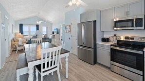 A modern kitchen with a large island, stainless steel appliances, and a ceiling fan. - "Close Call" - Oceanfront Home, 4 Bedrooms / 3 Bathrooms (Holden Beach)