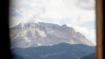 Una cordillera con un pico destacado, densos valles boscosos y un cielo nublado.