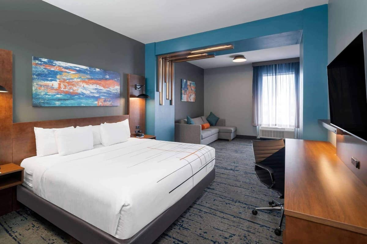 Une chambre d’hôtel avec un grand lit, un canapé, un bureau et une télévision.