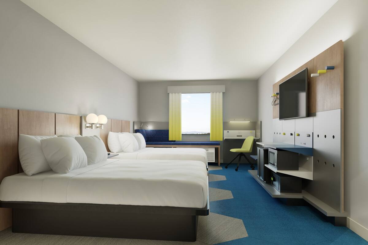 A hotel room with two beds, a desk, a chair, a TV, and a window with curtains.