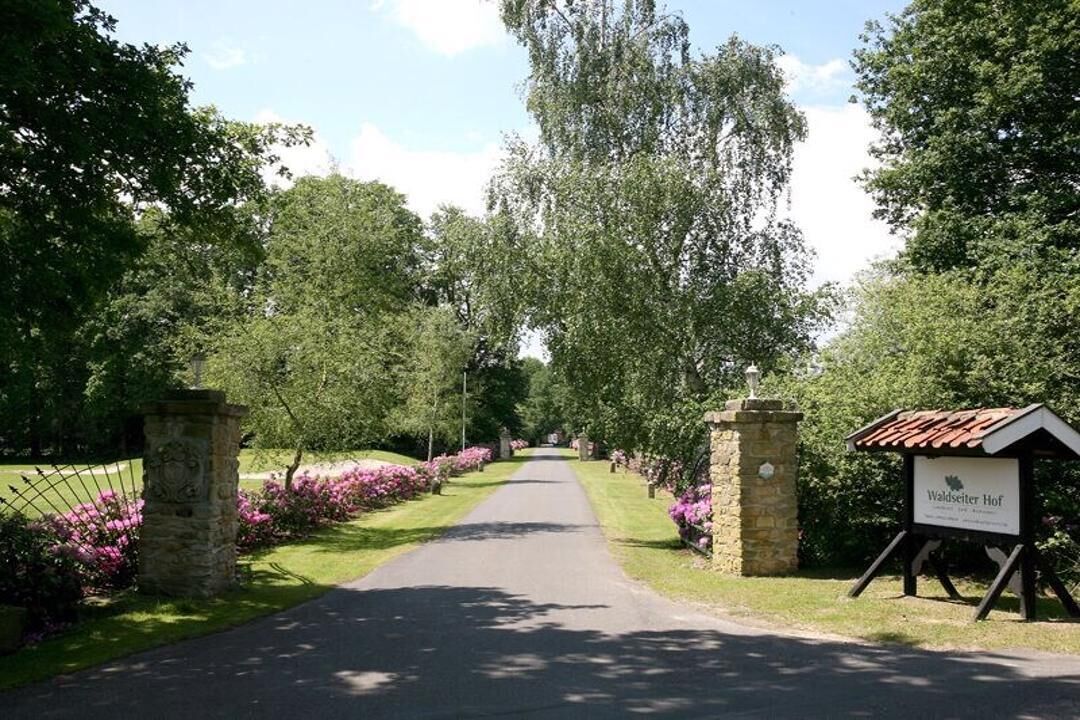 A pathway leading to a building with a sign reading "Waldseiter Hof."