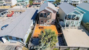 A coastal residential area with houses featuring balconies and a central building with a red roof.