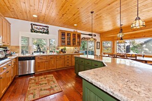 A kitchen with wooden cabinets, a granite countertop, and a dishwasher.