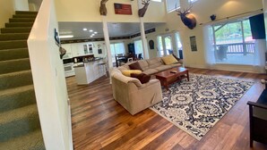A spacious living area with a staircase, a kitchen, and a dining area.