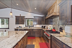 A modern kitchen with dark wood cabinets, granite countertops, and a central island.