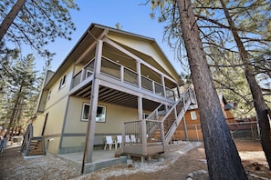 A two-story building with a balcony, a staircase, and a fenced outdoor area.