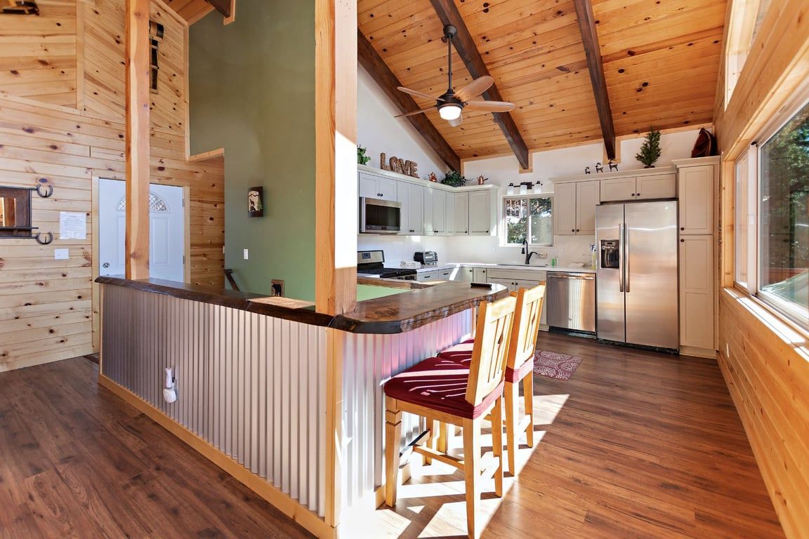 Une cuisine moderne avec des meubles en bois, un îlot central et un ventilateur de plafond.