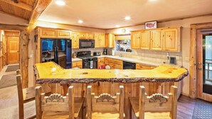 Una cocina con armarios de madera, encimera de granito y estufa integrada.