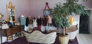 Experience a classic boutique setting with ornate mirrors, stylish mannequins, and elegant armchairs.