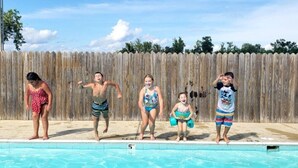 Une piscine avec une clôture en bois en arrière-plan.