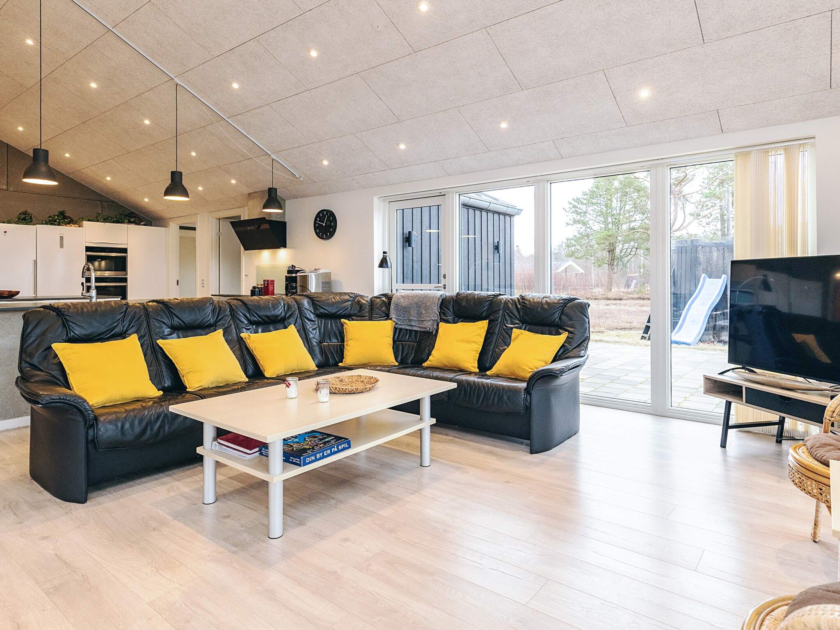 A modern living room with a sectional sofa, a coffee table, and a television.