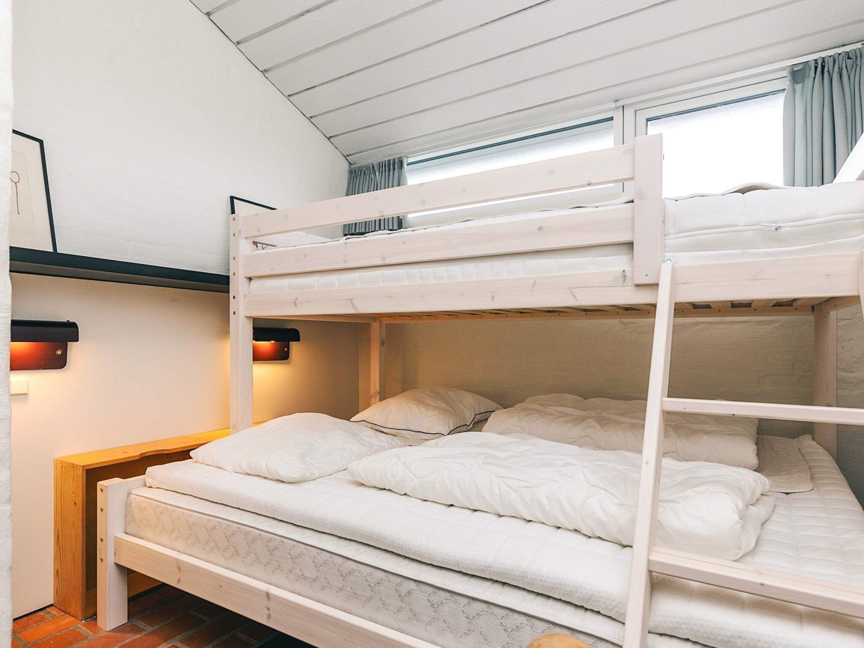 A bunk bed with a lower level bed and a bunk above.